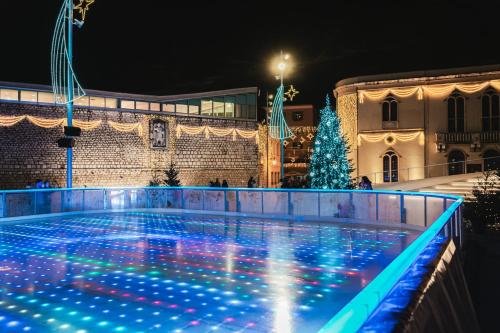 a swimming pool with christmas lights in front of a building at City Heart Residence in Šibenik