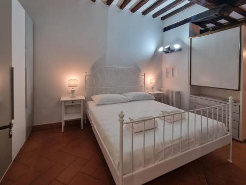 een slaapkamer met een wit bed en 2 nachtkastjes bij Borgo Allegri Apartment in Florence