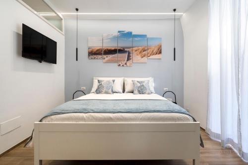 a bedroom with a bed and a tv on a wall at Dolci Coccole Small Suite a Bari città! in Bari
