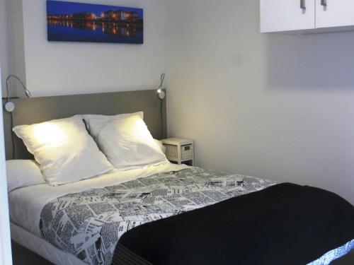 une chambre avec un lit avec une couette noire et blanche dans l'établissement Facile, Lumineux, Parking, Metro, proche du Centre, à Toulouse