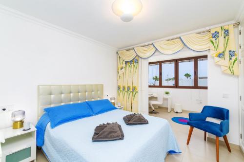 a bedroom with a bed and a blue chair at Villa Tisalaya by Villa Plus in Puerto del Carmen
