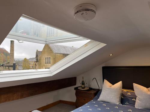 um quarto com uma cama e uma grande janela em Bonsalls Central Hebden Bridge em Hebden Bridge