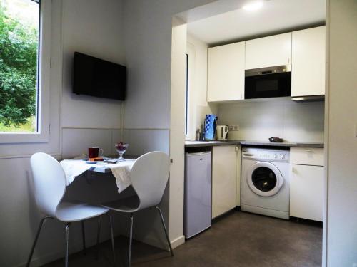 une petite cuisine avec une table et un lave-linge. dans l'établissement Facile, Lumineux, Parking, Metro, proche du Centre, à Toulouse