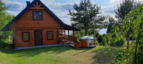 a small house with a gazebo in the yard at Dereniowe Wzgórze in Sejny