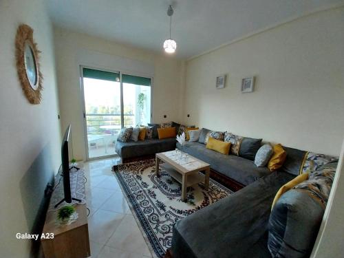 ein Wohnzimmer mit einem Sofa und einem Tisch in der Unterkunft Large Appartement Rabat Salé - SwiftStay - Sidi Abdellah in Salé