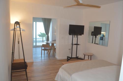 a bedroom with a bed and a flat screen tv at Excepcional Apartamento AMANECER CABO a pie de playa y mar,NUEVO A ESTRENAR in Alicante