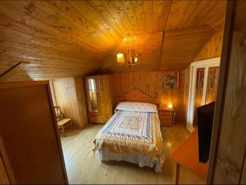 ein Schlafzimmer mit einem Bett in einer Holzhütte in der Unterkunft Apartamento cerca de la granja in Palazuelos de Eresma