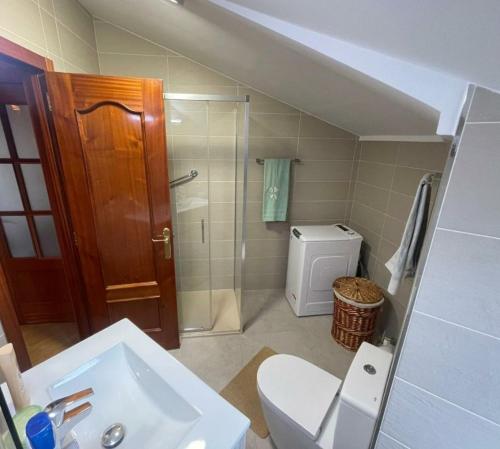 a bathroom with a toilet and a shower and a sink at Apartamento cerca de la granja in Palazuelos de Eresma