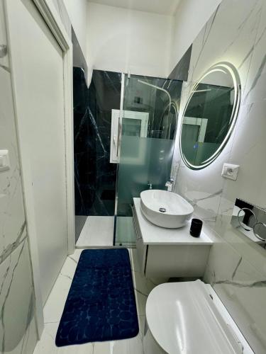 a bathroom with a sink and a toilet and a mirror at Onny's House in Bari