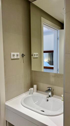 a bathroom with a white sink and a mirror at Sunraf Luxe Apartments in Budva