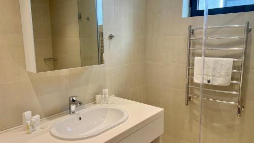 a white bathroom with a sink and a shower at Sunraf Luxe Apartments in Budva