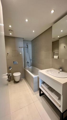 a bathroom with a sink and a toilet and a tub at Sunraf Luxe Apartments in Budva