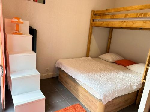une chambre avec un lit superposé avec des draps blancs dans l'établissement Appartement Confort Centre des Gets, Proche Remontées, Terrasse, Animaux Bienvenus - FR-1-623-82, aux Gets