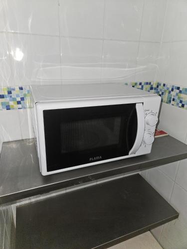 a microwave sitting on a shelf in a kitchen at Hotel Adelaide in Faro