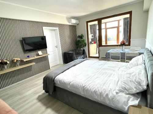 a bedroom with a bed and a flat screen tv at Baneasa Luxury Apartaments in Bucharest