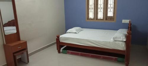 a small bedroom with a bed and a mirror at Hallima Home Stay Services Golden Nagar in Pudukkottai