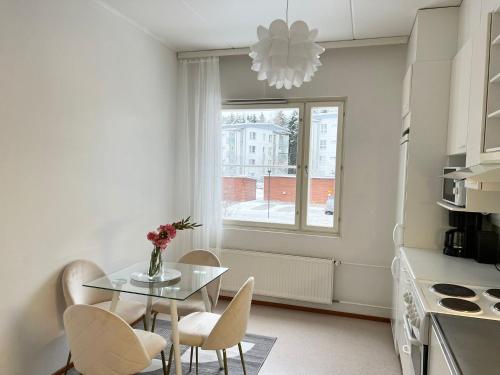 a kitchen with a table and chairs and a window at Star of Annala in Tampere