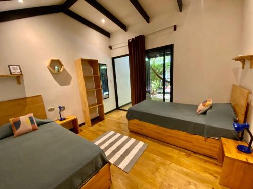 Duas camas num quarto com pisos em madeira em Santeria Lodge em Santa Teresa