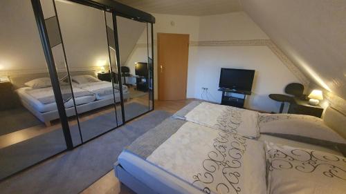 a bedroom with a large bed and a television at Ferienwohnung Hahnentange in Rhauderfehn
