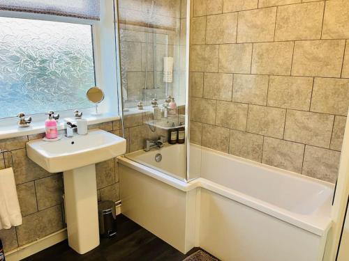 a bathroom with a sink and a tub and a shower at Stylish Central Apartment in Cardiff