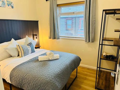a bedroom with a bed with two towels on it at Stylish Central Apartment in Cardiff