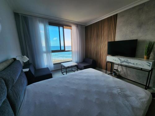 een hotelkamer met een groot bed en een televisie bij maytoro in Haifa