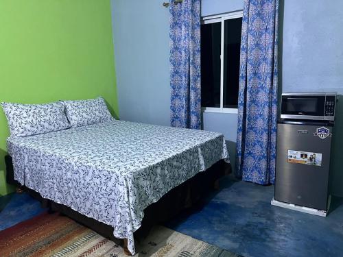 um pequeno quarto com uma cama e uma janela em SerenitHe em Negril