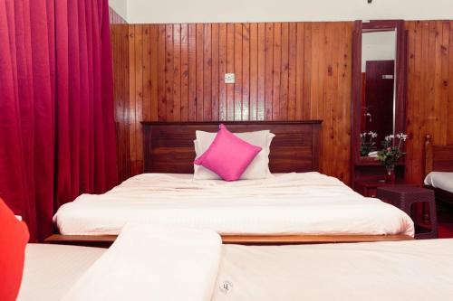 a bedroom with two beds with a pink pillow at Villa Florence in Nuwara Eliya