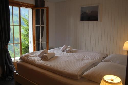 a bed with towels on top of it with a window at Le Loup, grand chalet coup de cœur in Moleson