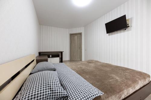 1 dormitorio con 1 cama y TV en la pared en 0272 Нова затишна квартира ЖК Щасливий, en Kiev