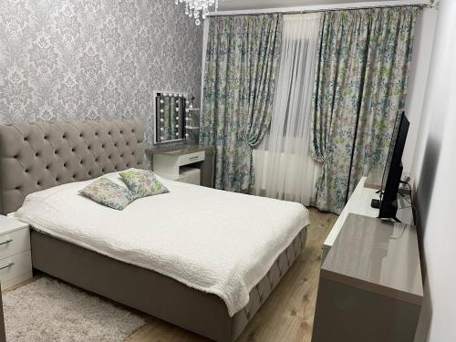 - une chambre avec un lit et un bureau avec une télévision dans l'établissement Urban Harmony Loft, à Bucarest