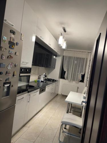 - une cuisine blanche avec une table et un réfrigérateur dans l'établissement Urban Harmony Loft, à Bucarest