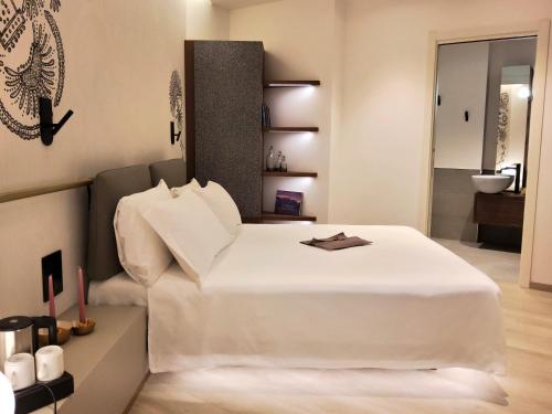 a bedroom with a white bed and a bathroom at Panorama Hotel Friuli - Boutique Hotel in San Daniele del Friuli