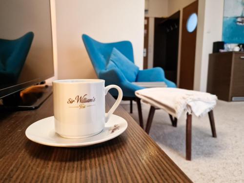 a coffee cup sitting on a table with chairs at Hotel 77 Restauracja Spa in Chałupy