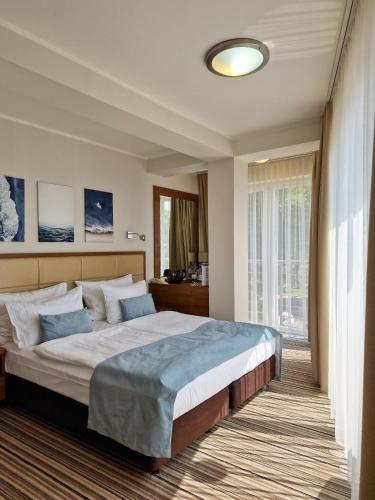 a bedroom with a large bed and a window at Hotel 77 Restauracja Spa in Chałupy