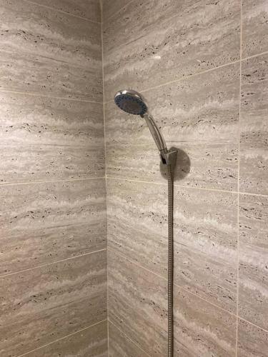 y baño con ducha con cabezal de ducha. en استديو بتصميم أنيق ودخول ذاتي, en Riad