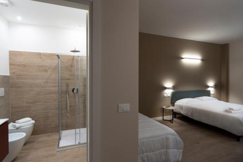 ein Schlafzimmer mit einem Bett und ein Badezimmer mit einer Dusche in der Unterkunft Astoria Comfort Rooms in Bologna