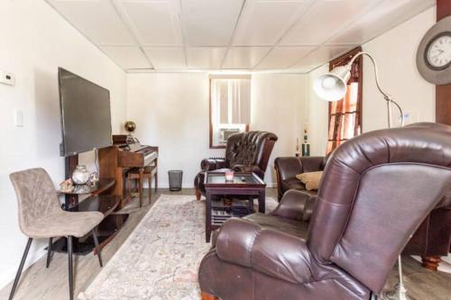 a living room with a leather couch and a television at cozy room with private bathroom in Arlington