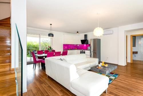 ein Wohnzimmer mit einer weißen Couch und einem Tisch in der Unterkunft Villa NIKA in Srima