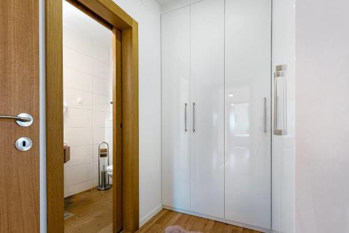 ein Flur mit weißen Schränken in einem Badezimmer in der Unterkunft Villa NIKA in Srima