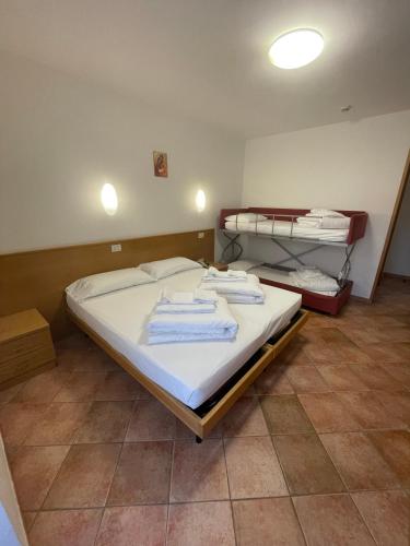 a bedroom with a bed with towels on it at Casa Santa Maria in Folgaria