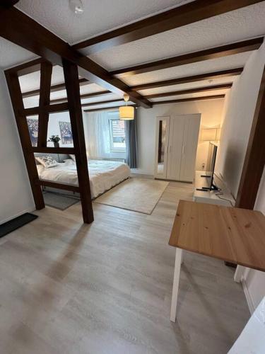 ein Wohnzimmer mit einem Bett und einem Holztisch in der Unterkunft Ferienwohnung zur Sternblume in Bruchweiler-Bärenbach