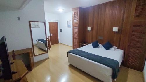1 dormitorio con cama y espejo en Hotel Tenda, en Marília