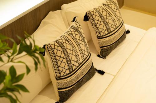 two pillows sitting on a shelf with a plant at Shenzhen Semporna Beach Sea View B & B - 深圳较场尾仙本那沙滩海景民宿 in Shenzhen
