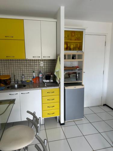 eine kleine Küche mit gelben und weißen Schränken in der Unterkunft Gran Lencois Flat Residence in Barreirinhas