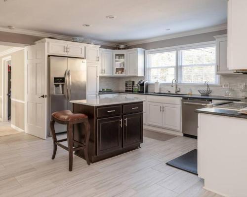a kitchen with white cabinets and a bar stool at Fernwood Manor in High Point