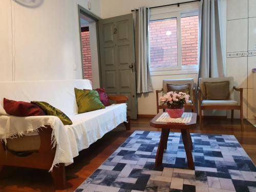 sala de estar con sofá blanco y mesa en Apartamento a DUAS quadras do Centro, en Gramado