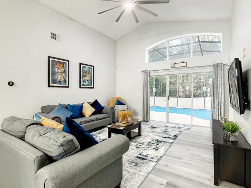 a living room with two couches and a large window at Casita mi Encanto a Cozy & Spacious House, 4-bedroom 3-Bath & pool in Kissimmee