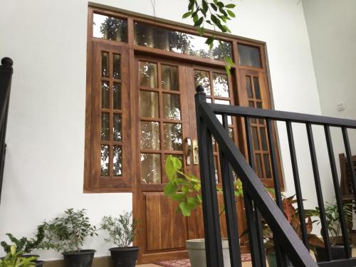a wooden door on a building with potted plants at Kandyan Lounge in Kiribatkumbura