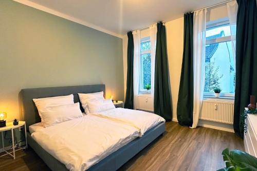 a bedroom with a bed and two windows at City Apartment in Krefeld in Krefeld